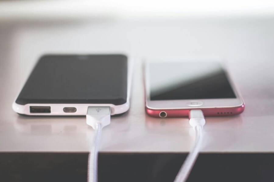 Two smartphones charging side by side on a desk. Modern and technological setting.
