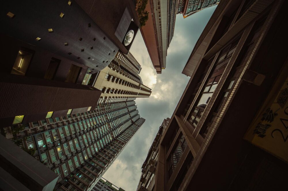 Low angle shot of Hong Kong skyscrapers creating a striking architectural perspective.
