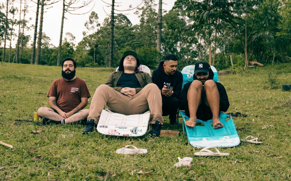 Group of men relaxing on lawn chairs in Natividade da Serra, Brazil, enjoying leisure in a lush green park.