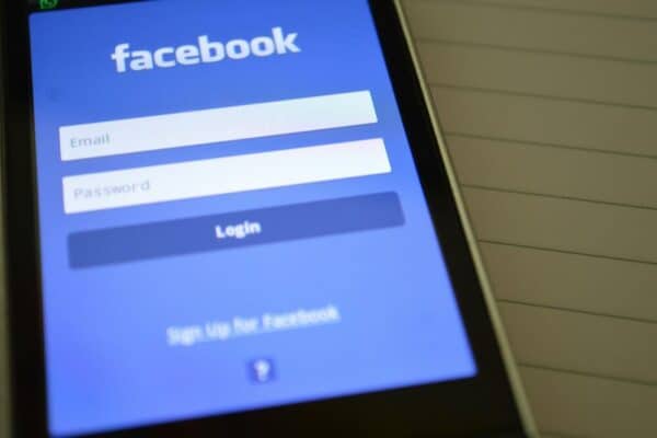 Facebook登入畫面，手機顯示Facebook登入頁面，顯示電子郵件和密碼輸入框，強調社群媒體、數位行銷和線上平台連結。.