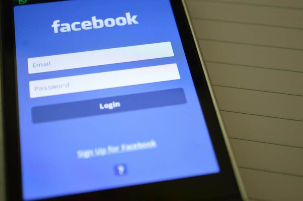 Facebook登入畫面，手機顯示Facebook登入頁面，顯示電子郵件和密碼輸入框，強調社群媒體、數位行銷和線上平台連結。.