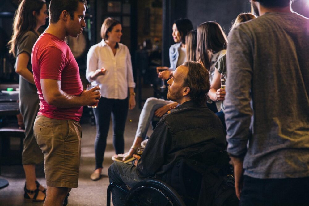 A diverse group socializing in a modern bar setting, promoting inclusion.