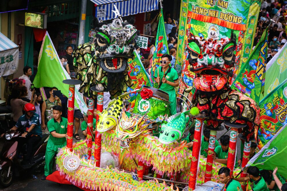 Colorful lion dance performance during a festive street parade in Ho Chi Minh City.