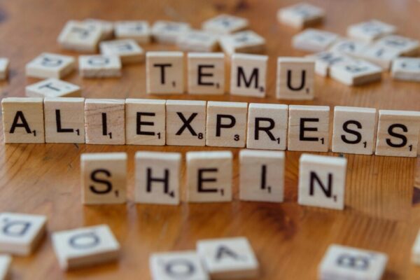 Shopify vs Shopee vs 蝦皮開店:台灣賣家如何選最適合? Wooden Scrabble tiles display popular e-commerce platforms on a wooden surface.