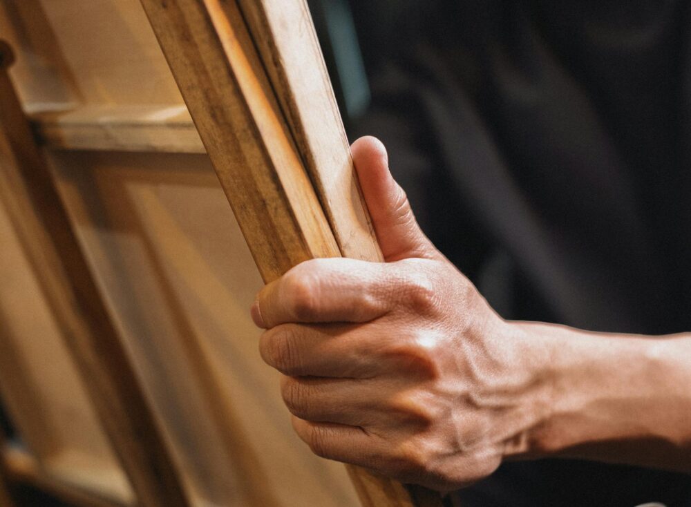 Detailed view of a hand grasping an easel, perfect for art and creativity themes.