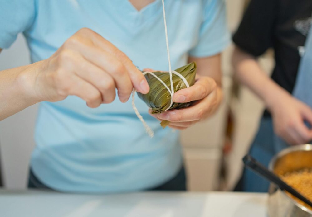 Close-up view of hands preparing rice dumplings at home in Tokyo, Japan.