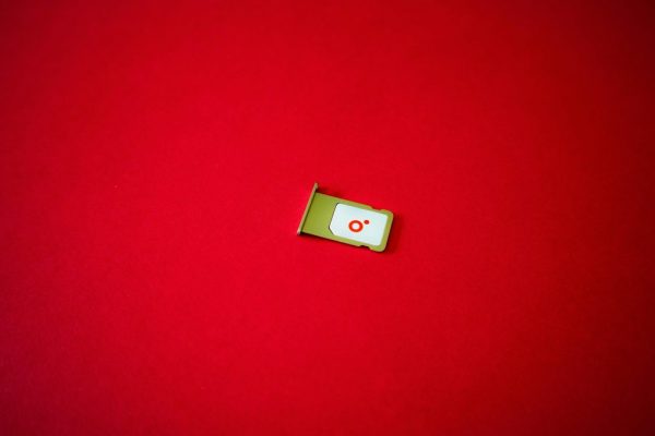 A clean image of a SIM card tray displayed on a vibrant red background.
