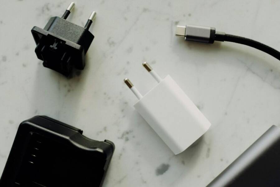 Collection of power adapters and a USB-C charging cable on a marble surface