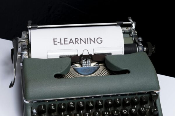 線上課程平台指南:個人網站 vs 第三方平台,哪種適合你? Close-up of a vintage typewriter displaying the concept of e-learning on paper