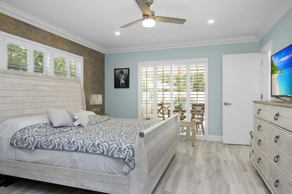 Spacious modern bedroom featuring coastal decor, natural light, and minimalist design elements.