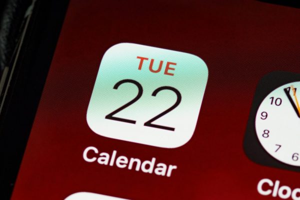 Detailed close-up of an iPhone home screen focused on the calendar app icon.