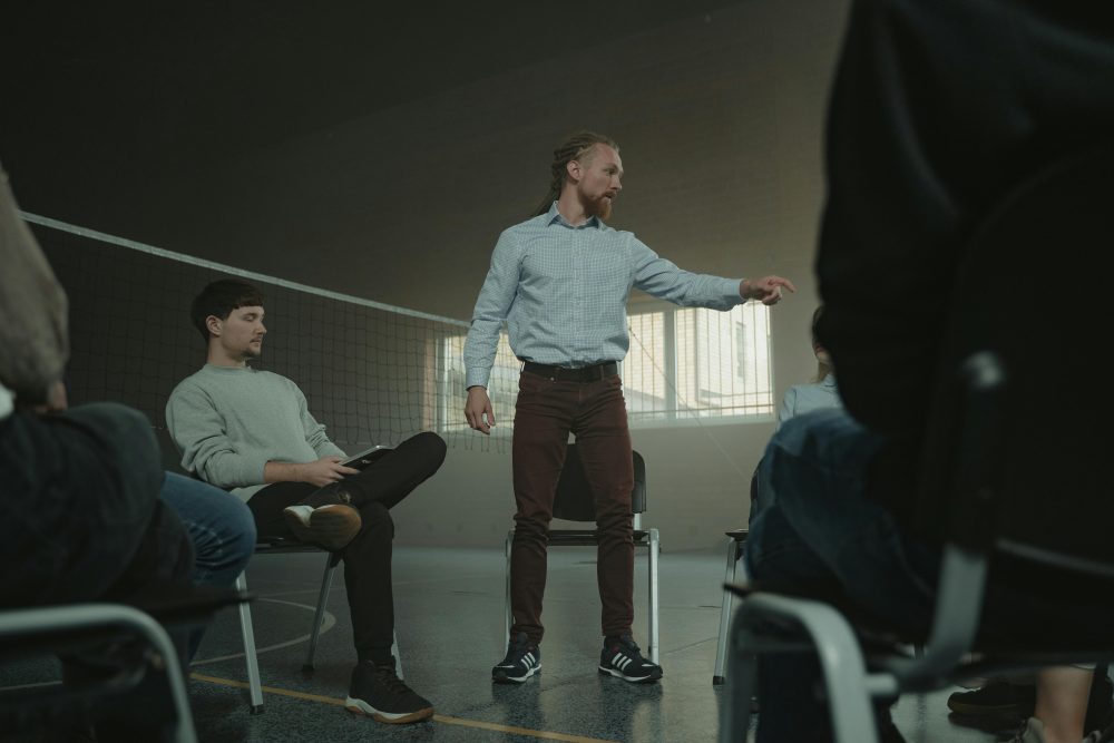 A group therapy session indoors with diverse adults engaging in discussion and support.