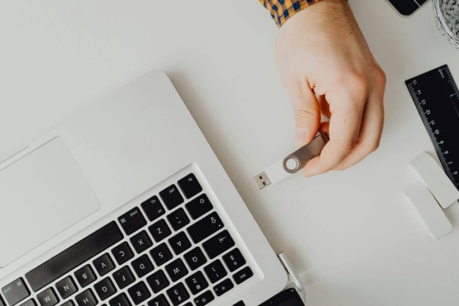 Hand inserting USB drive into laptop