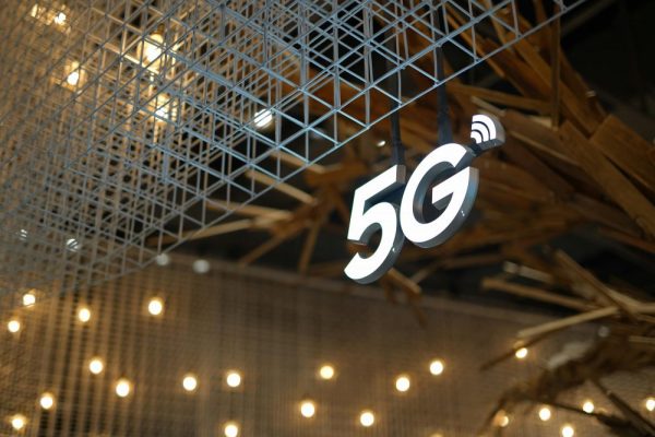 Illuminated 5G sign with modern geometric ceiling and warm lighting