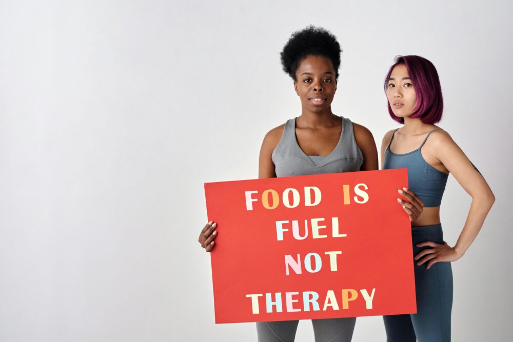 Two women holding a sign saying