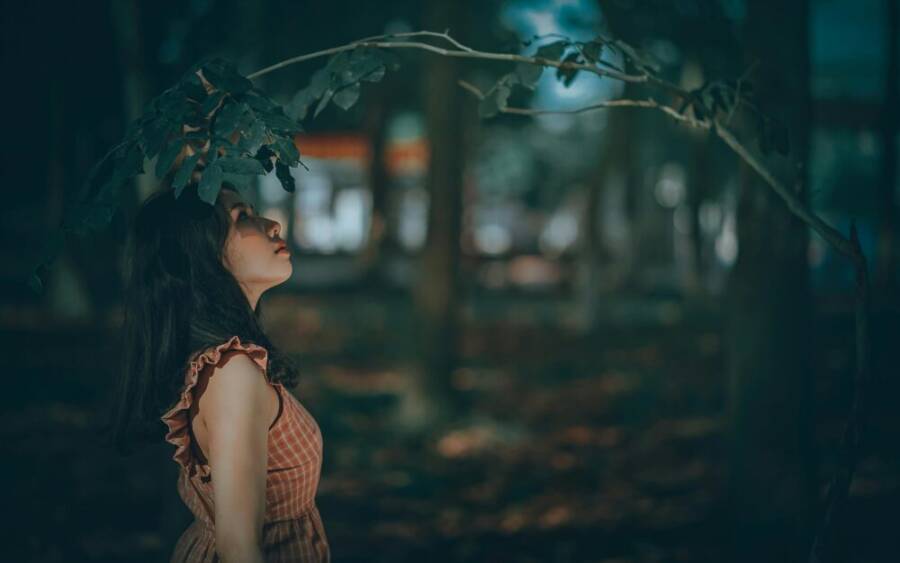A captivating portrait of a woman in a serene forest setting, embracing nature