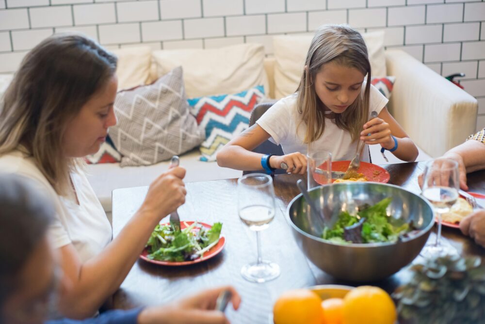 A family enjoying a healthy meal together indoors, emphasizing togetherness and healthy eating.