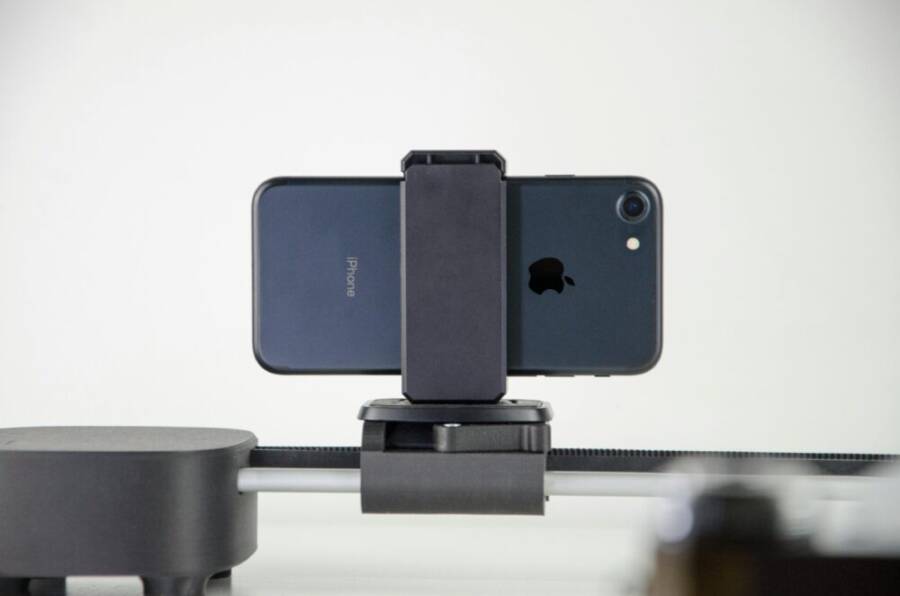 A close-up image of a smartphone mounted on a slider, ideal for video production and cinematic capturing