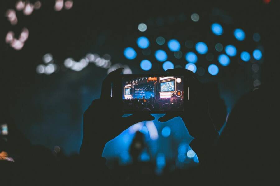 A vibrant concert scene captured through a smartphone, showcasing lively bokeh lights