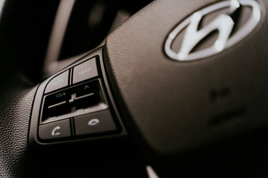 Detailed view of a car steering wheel with audio control buttons, focused on functionality.