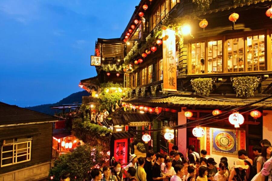 Vibrant evening view of Jiufen Old Street with lanterns and crowds in New Taipei City.