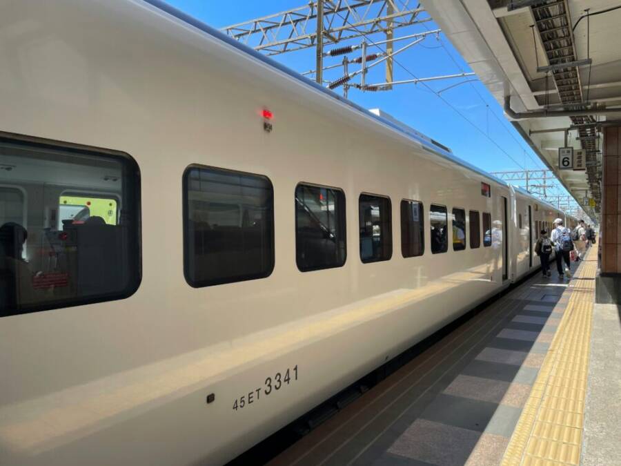 A modern high-speed train at Hualien Station under a clear blue sky