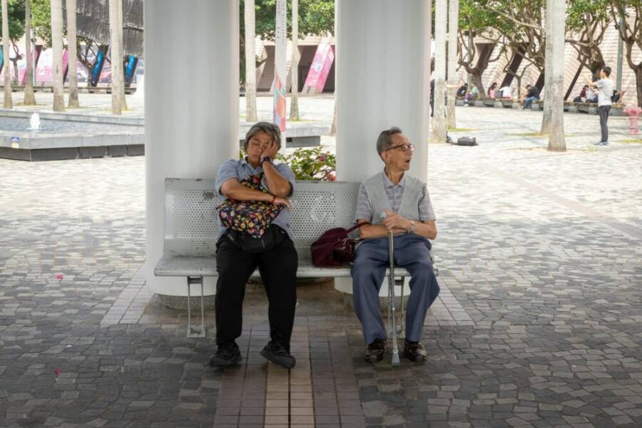 Senior adults sitting on a park bench in Hong Kong, enjoying a restful afternoon outdoors