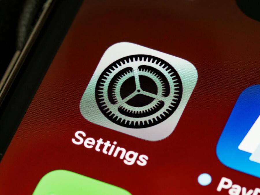 Detailed view of the iPhone screen showing the settings app icon