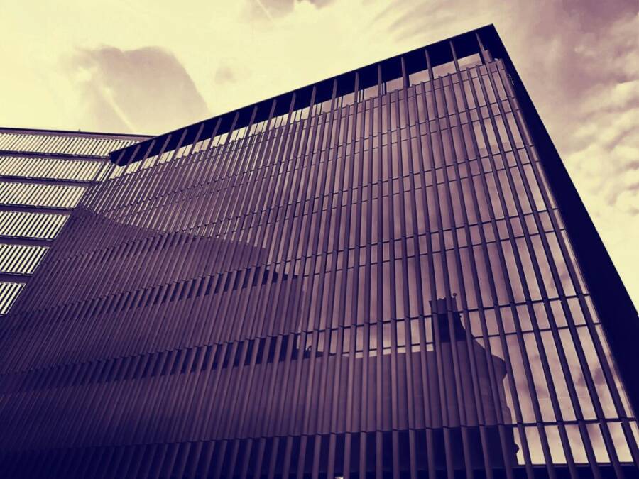 Low angle view of a modern skyscraper with a reflective glass facade and dynamic architectural lines