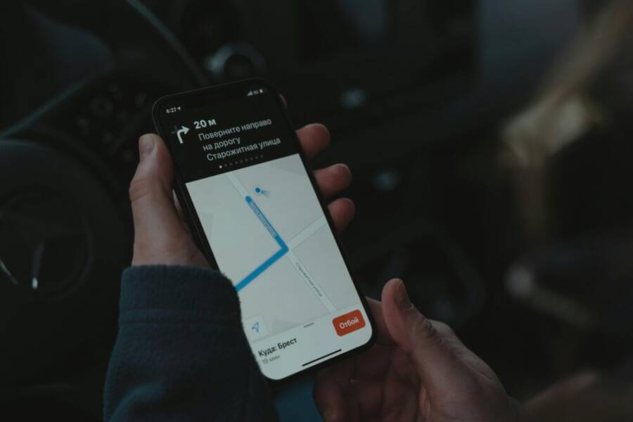 Close-up of a smartphone displaying navigation app in a car