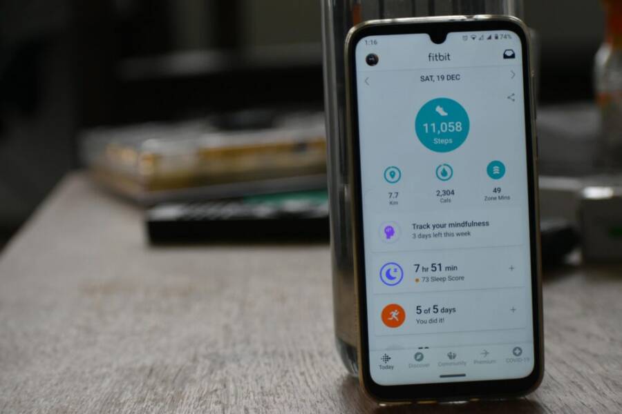 Close-up of a smartphone displaying a fitness tracking app with health statistics