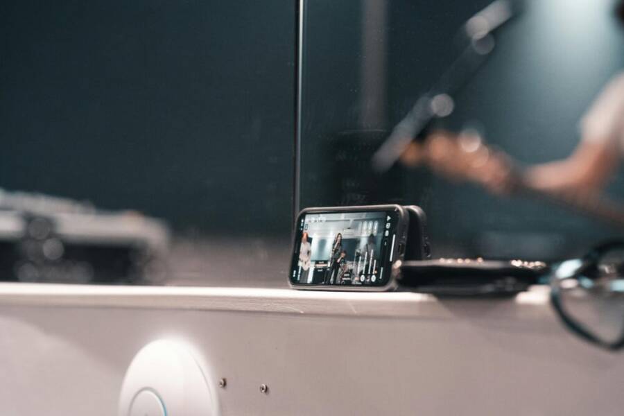 A smartphone recording a live band performance at an indoor event